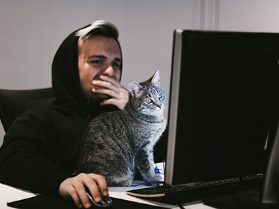 A man and his cat doing a test on his computer.