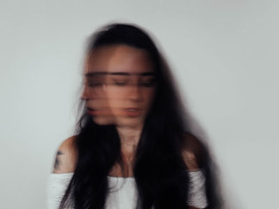 A woman with a blurred face to show anxiety.