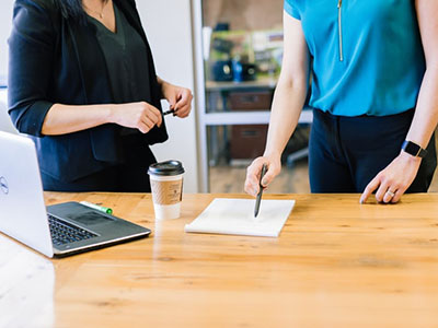 Two women going over notes in an office.