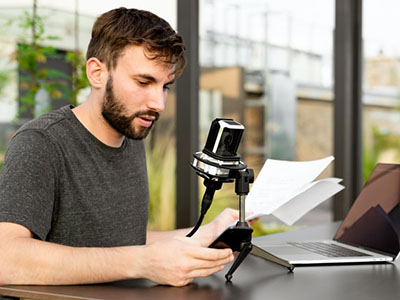 A man reading a script into a microphone.