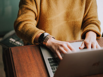 Person typing at a laptop.