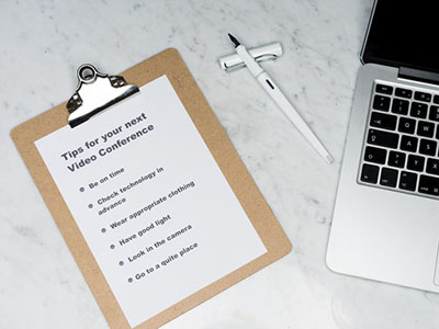 A list on a clipboard, next to a laptop.