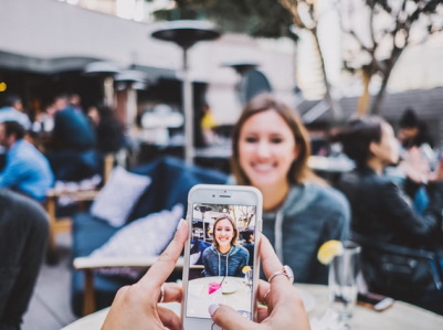 Someone taking a photo of a woman in a cafe.