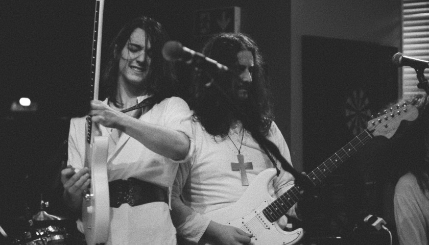 Two guitarists in a band perform in a pub in Lancaster.