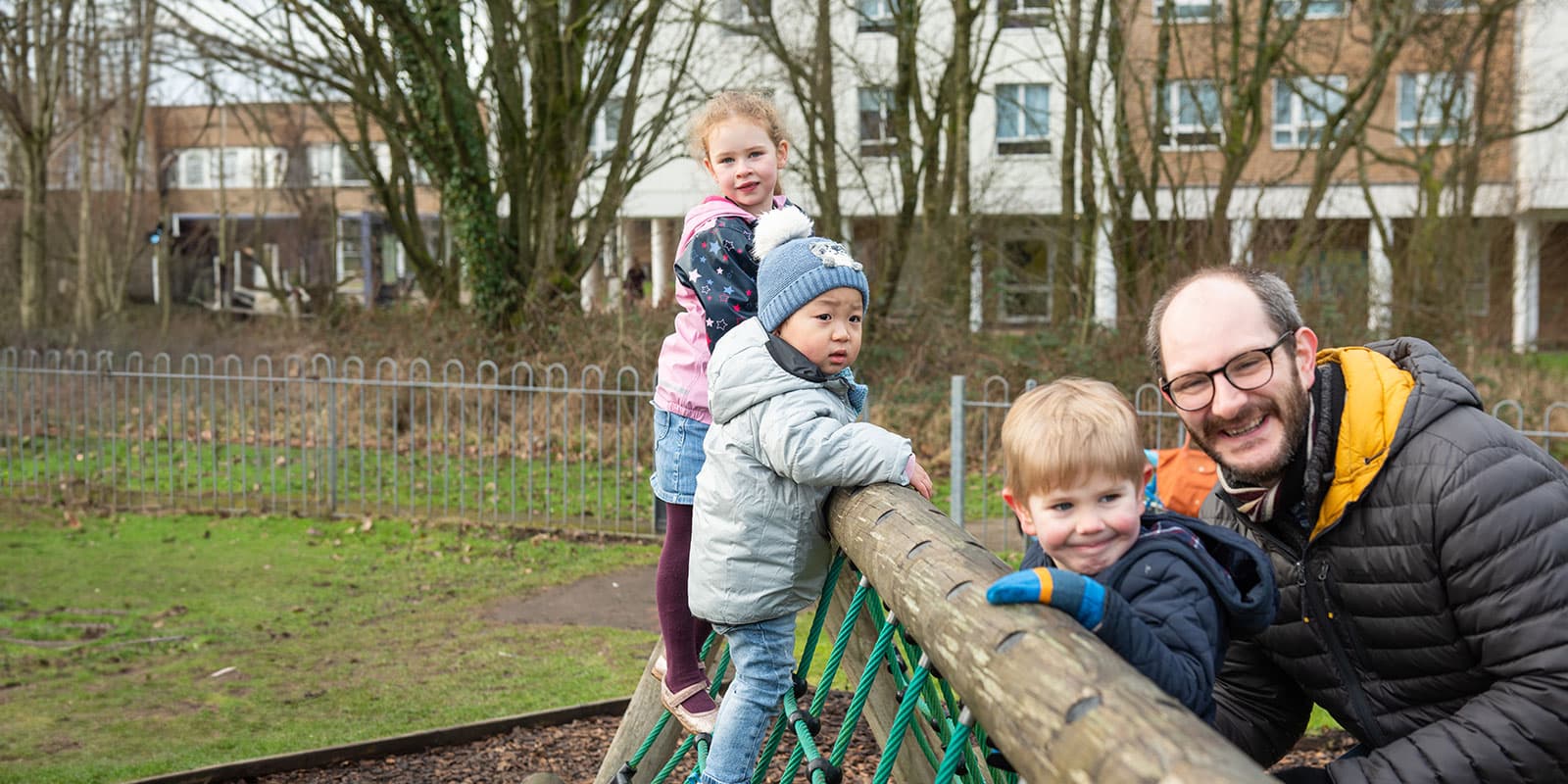 A family playing in the park, on campus.