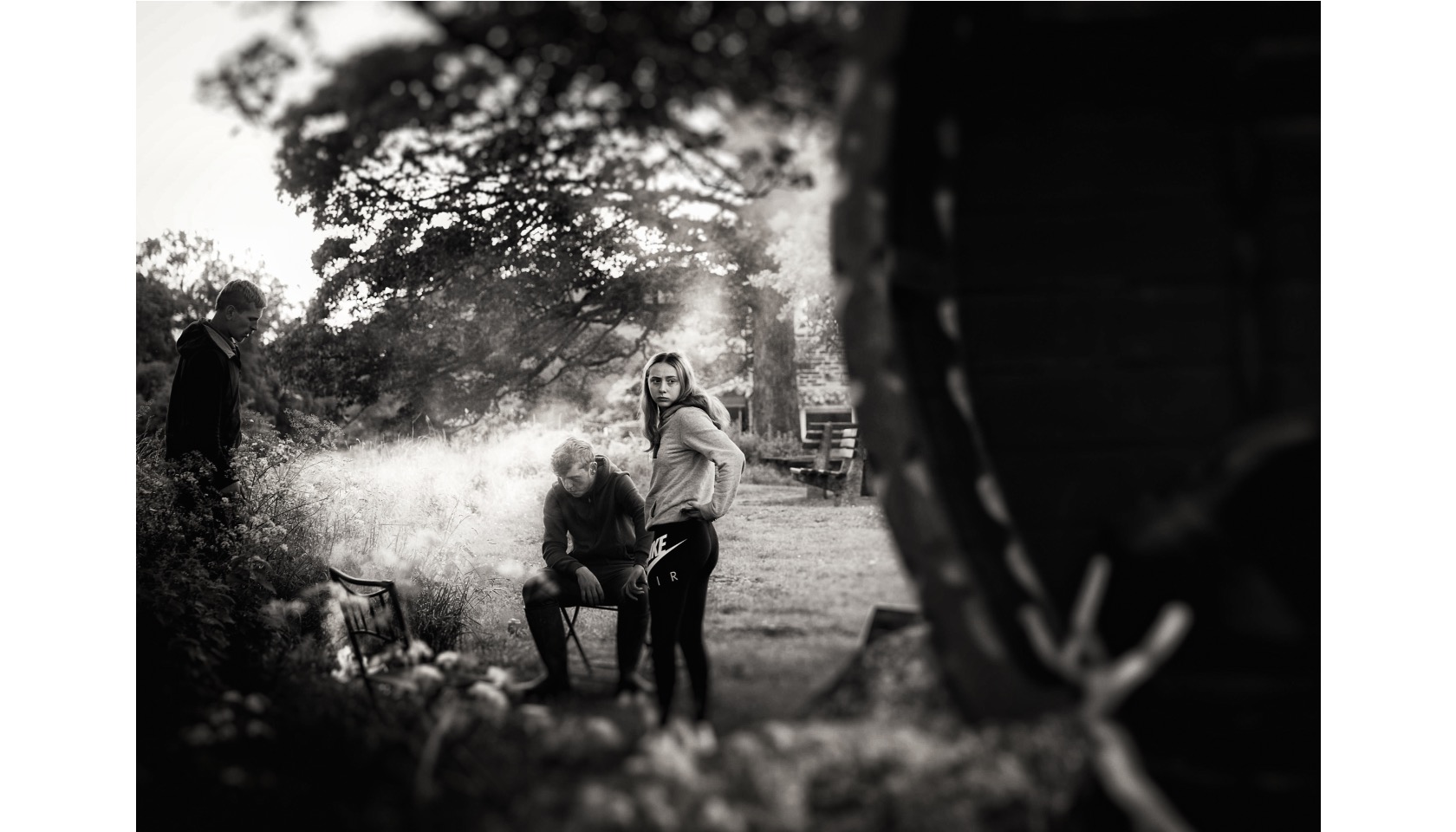 A man wearing a hat and holding a cigarette in his right hand.
