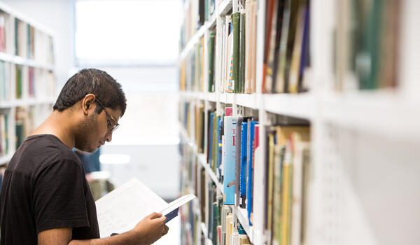 Man reading a book in the library