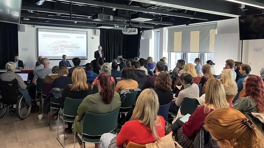 Image of staff sat in lecture theatre
