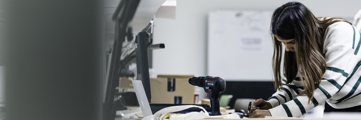 A student works in the Architecture studio making a 3D model.