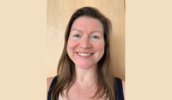 A woman with long dark hair, smiling