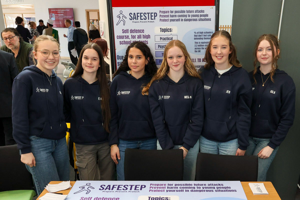 Six students in a row standing in front of a poster displaying the team's business idea