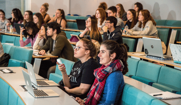 An academic delivering teaching stood in front of a large digital screen