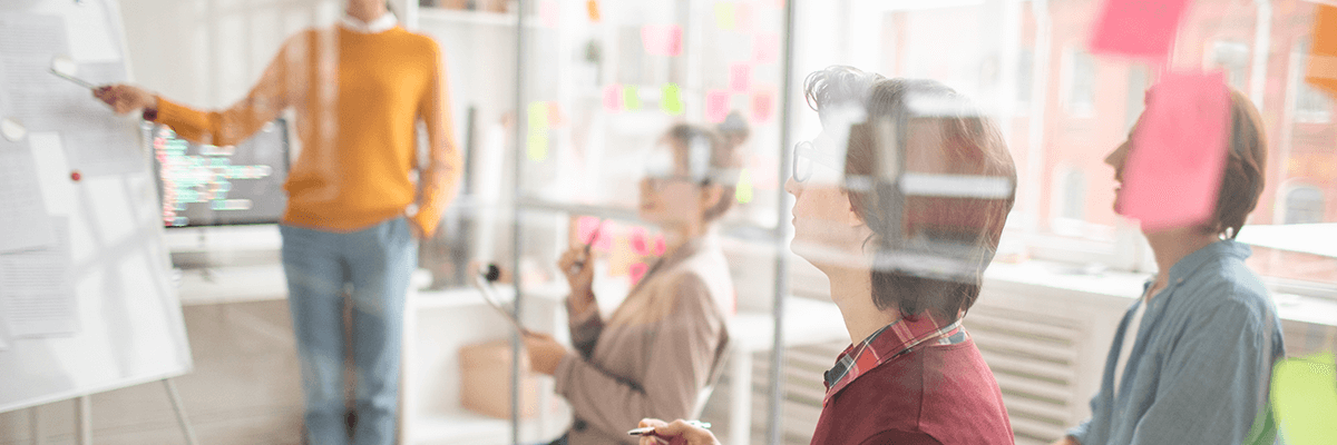 A group of people in a seminar room, viewed through a window