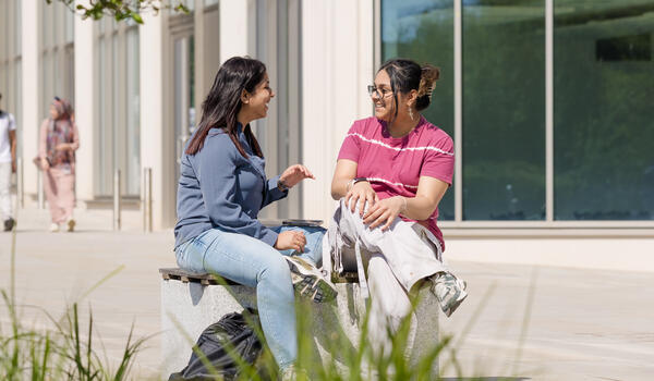 Pair of students talking outside the Management School building