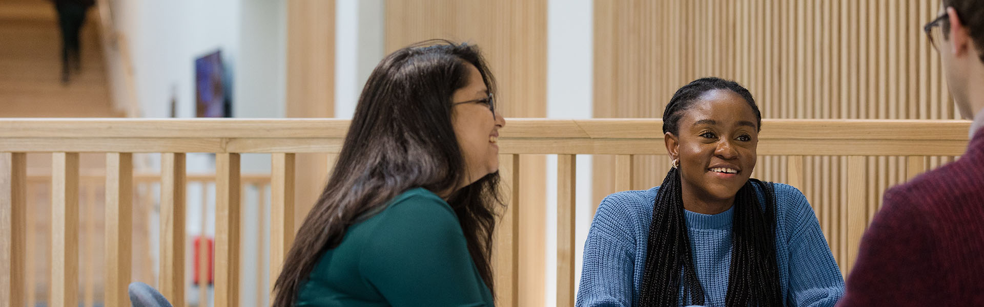 Students in conversation in a breakout space in the Lancaster University Management School building