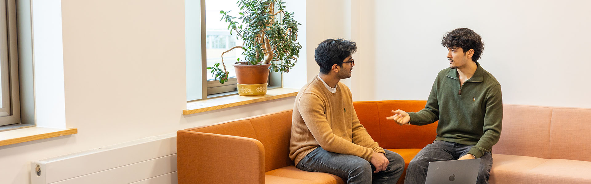 Shathvic and Gabriel, of 180 Degrees Consulting Lancaster, talking at a corner sofa