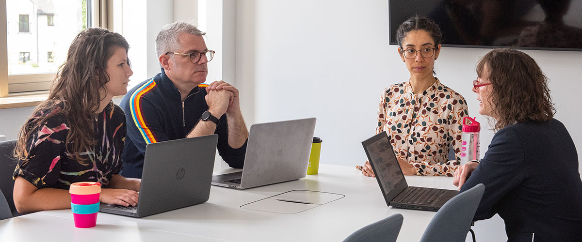 Group of four staff in a meeting room