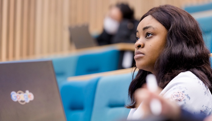 A student focuses during a lecture in the Management School