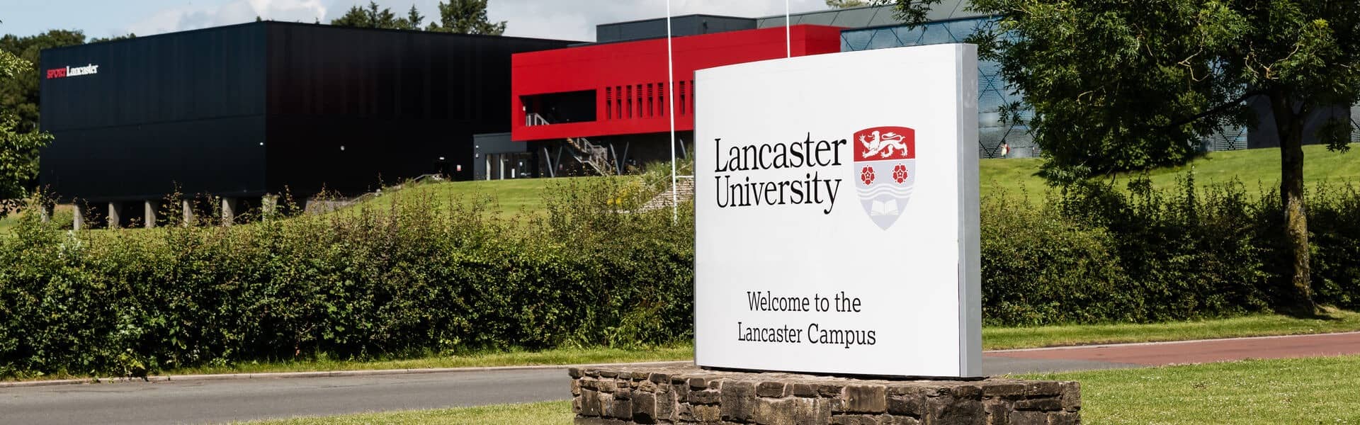 The main sign on the drive of the University.