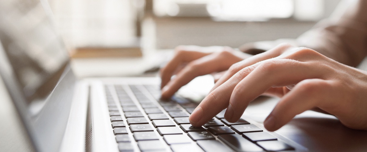 Fingers type on a keyboard.