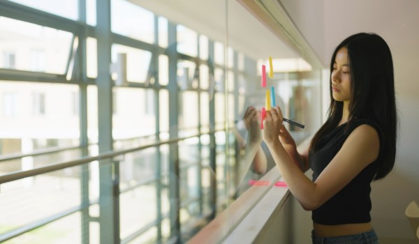 Student writing on post-it notes
