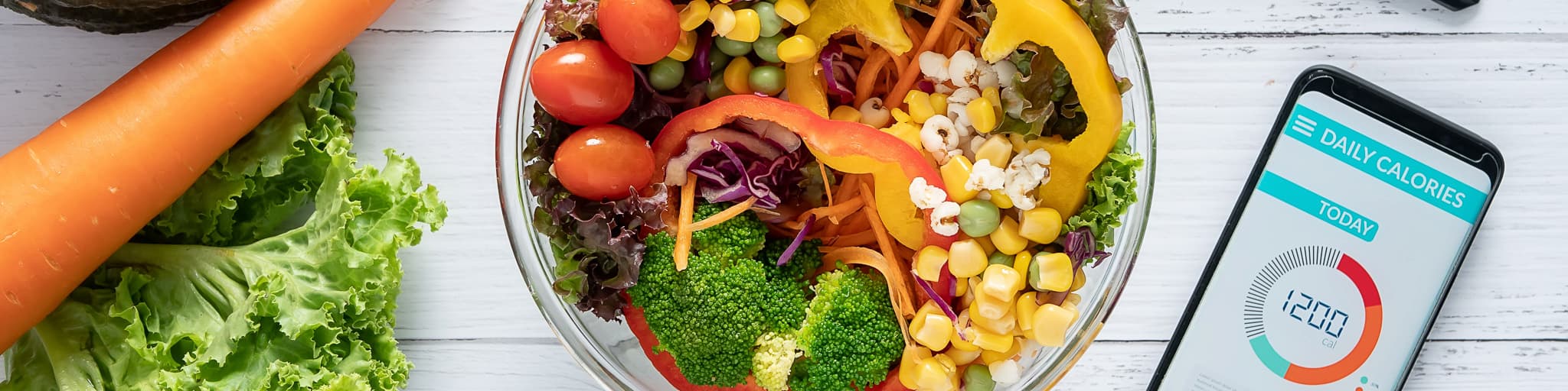 An image of fresh vegetables in a bowl next to an app for calorie counting
