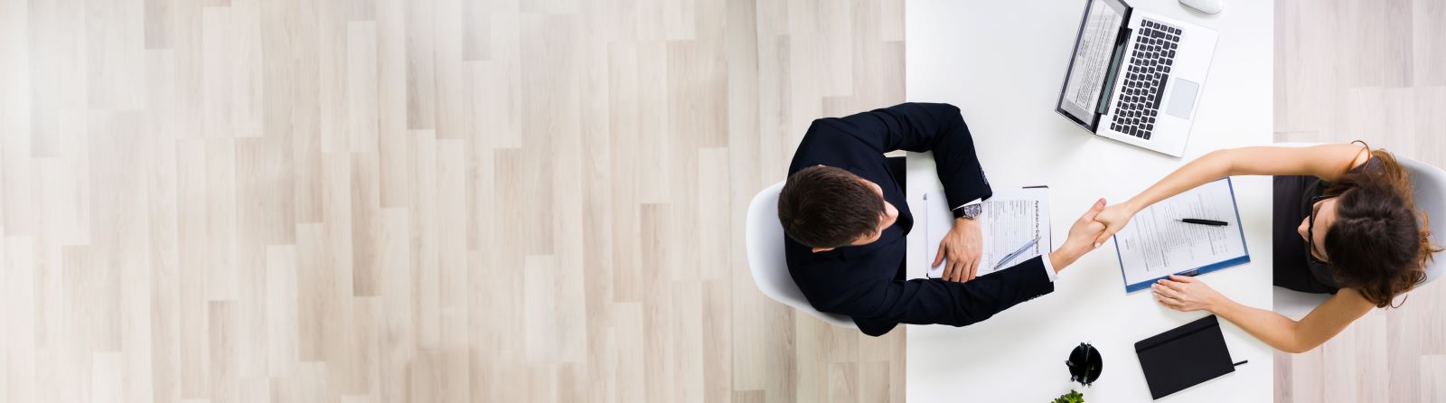 People sat shaking hands over a table.