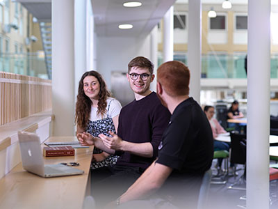 Three students working together with a lapptop
