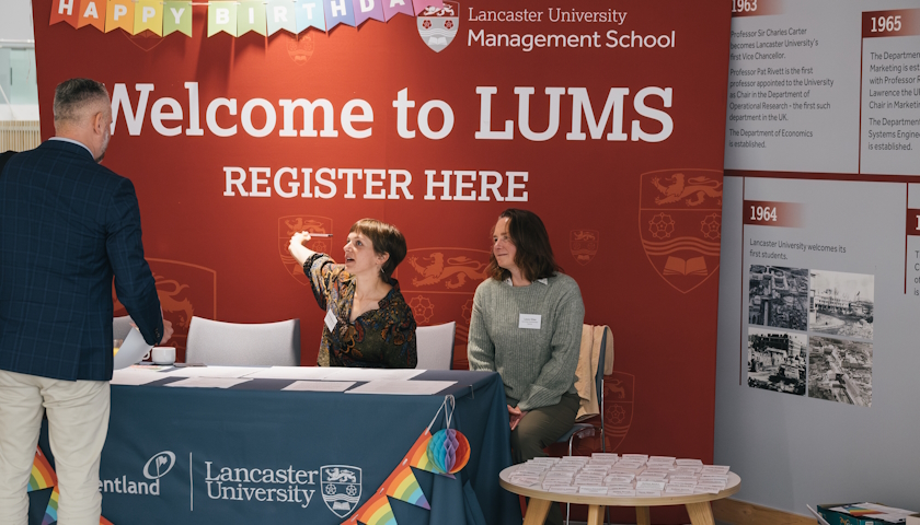 Izzy Hoggmascall and Laura Giles sitting behind a table with registration paperwork on it.