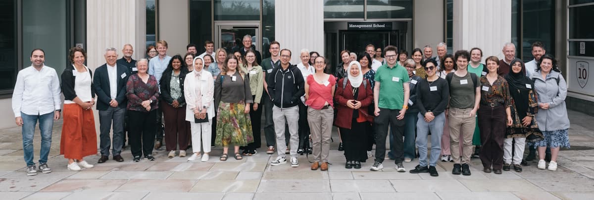A group photograph of approximately 50 participants at the Pentland Centre Festival of Sustainability 26 Jun 2025, standing outside Lancaster University Management School.