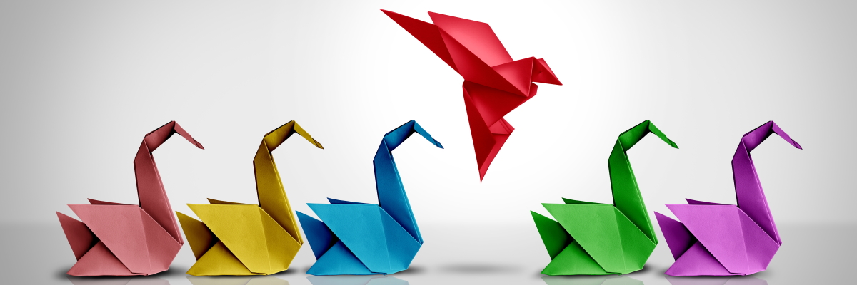 Origami birds of various colours in a row, with one appearing to land in an empty space