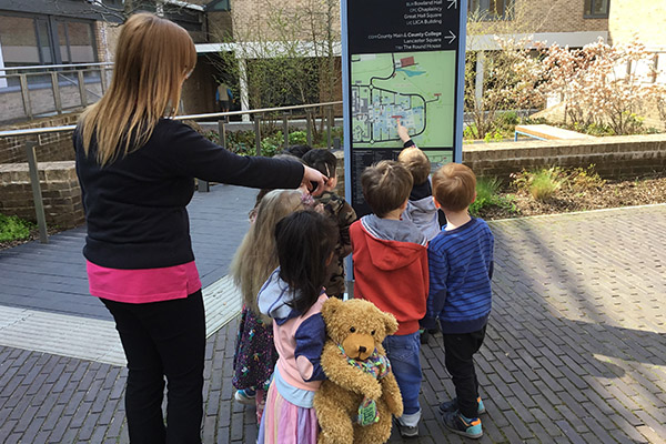 The children are navigating campus, pointing to one of the wayfinding makes on North Campus