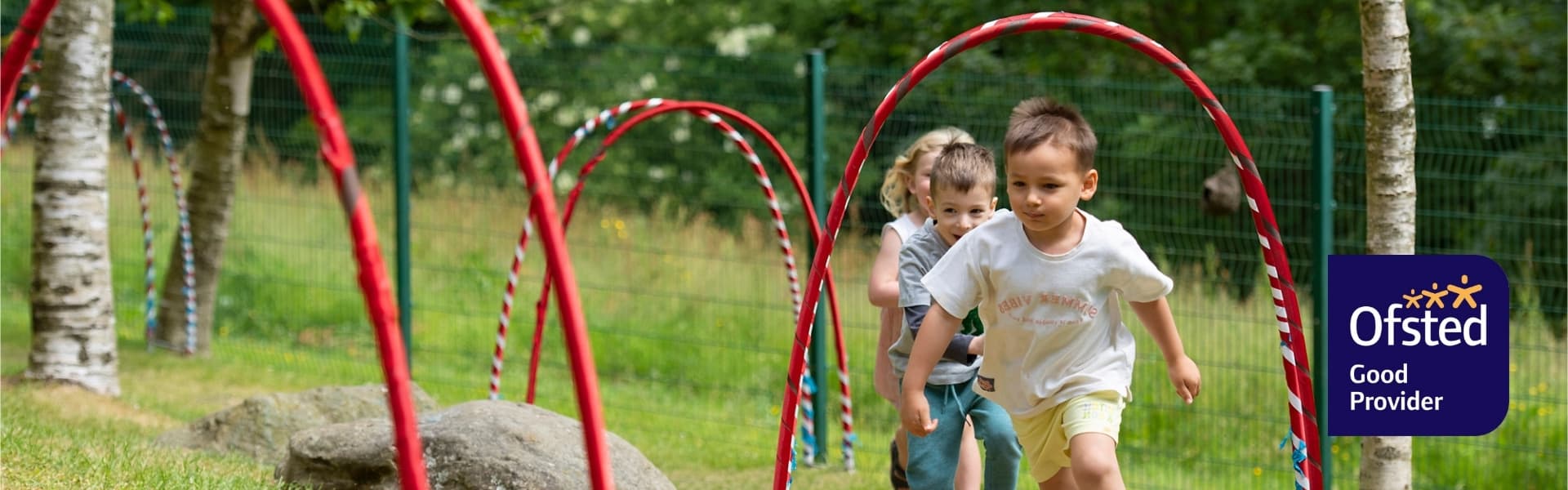 Three children running in the Pre-School Centre grounds.
