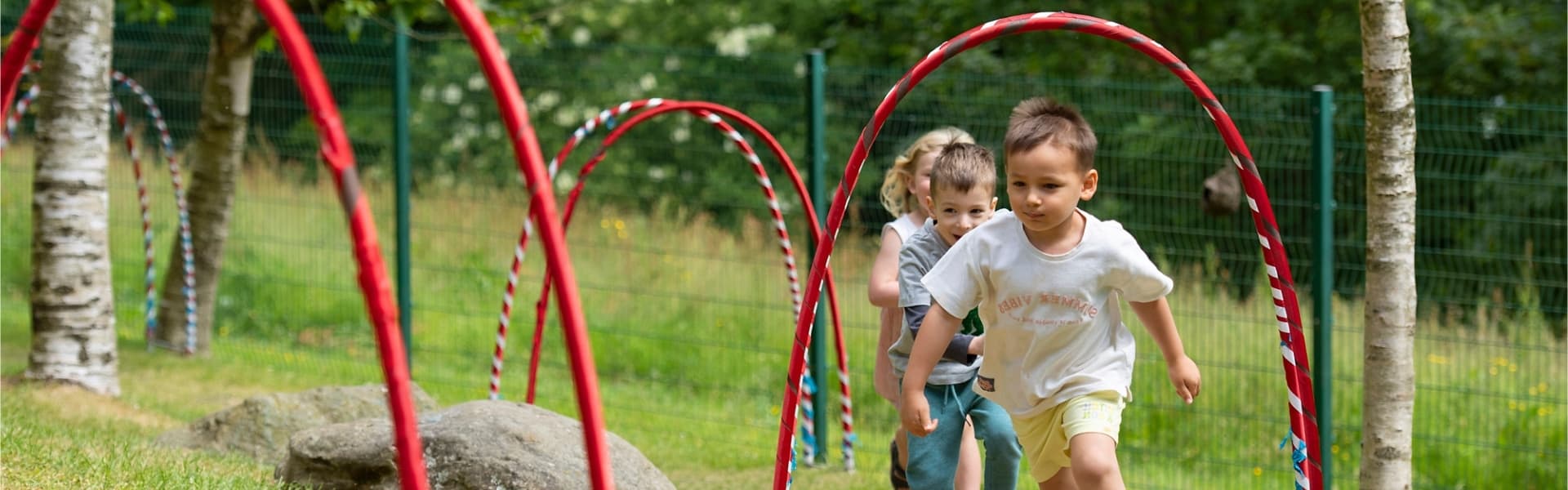 Three children running in the Pre-School Centre grounds.