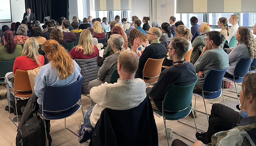 Participants listening to a presentation shot from the back of the room 