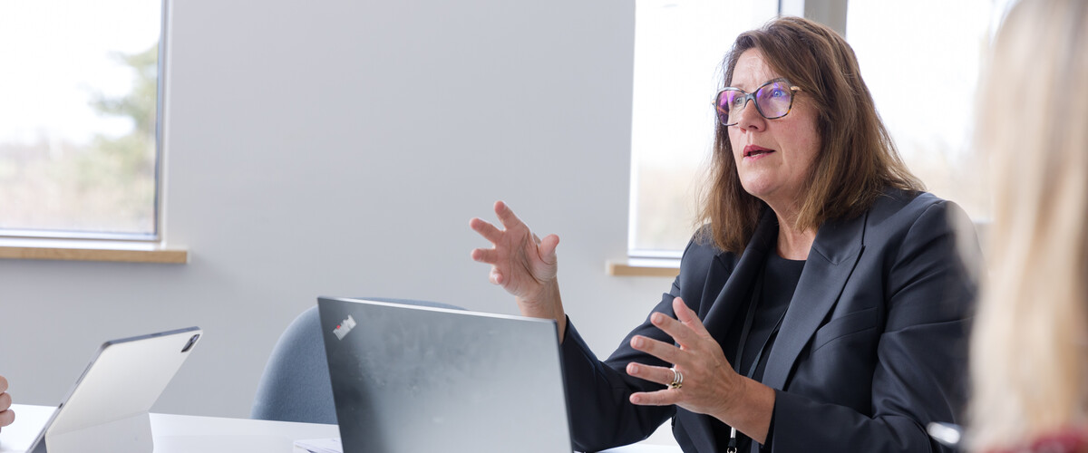 An academic gestures whilst discussing their subject in the Management School