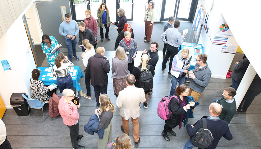 Participants networking and having refreshments in the Margaret Fell theatre foyer. 