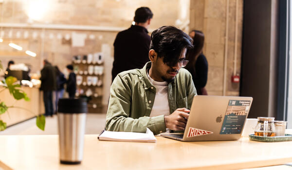 Student working on a laptop in the castle cafe