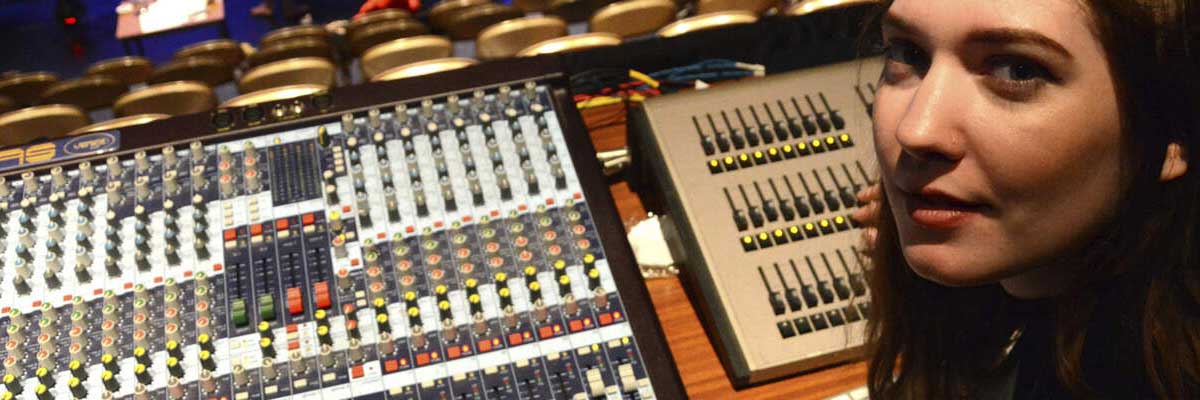  student sat at a theatre lighting deck