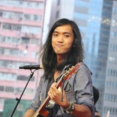 Aison playing guitar with a microphone