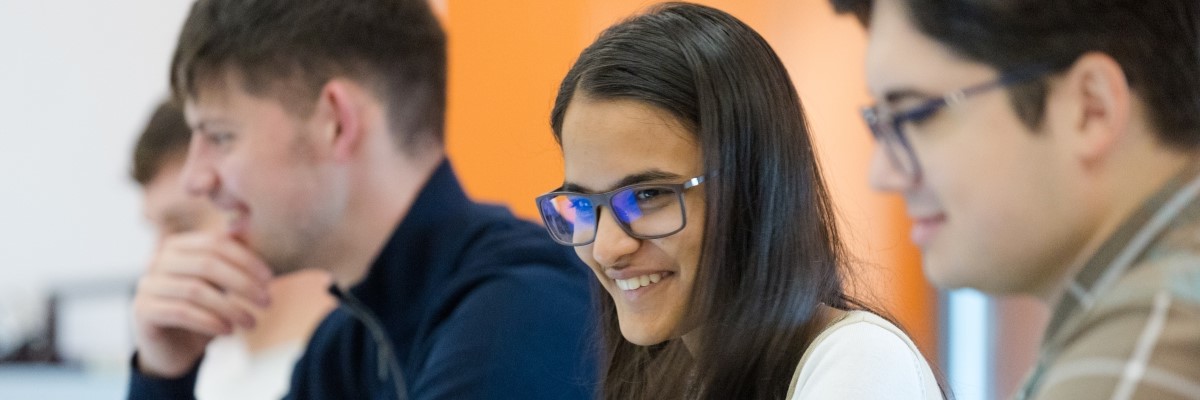 Student smiling and working alongside other students