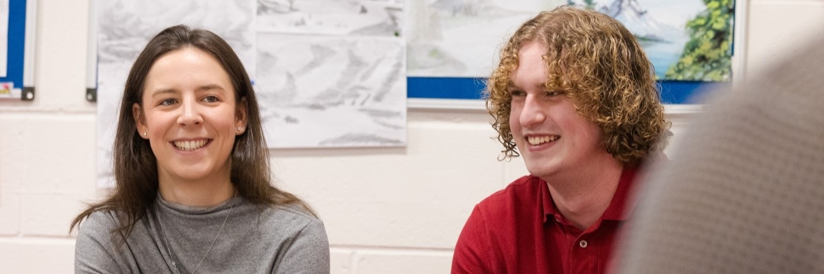 Student smiling at a computer screen