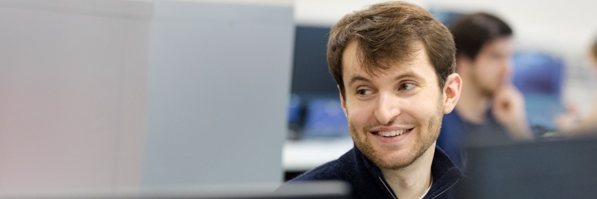 STOR=i student smiling off to the left of the camera