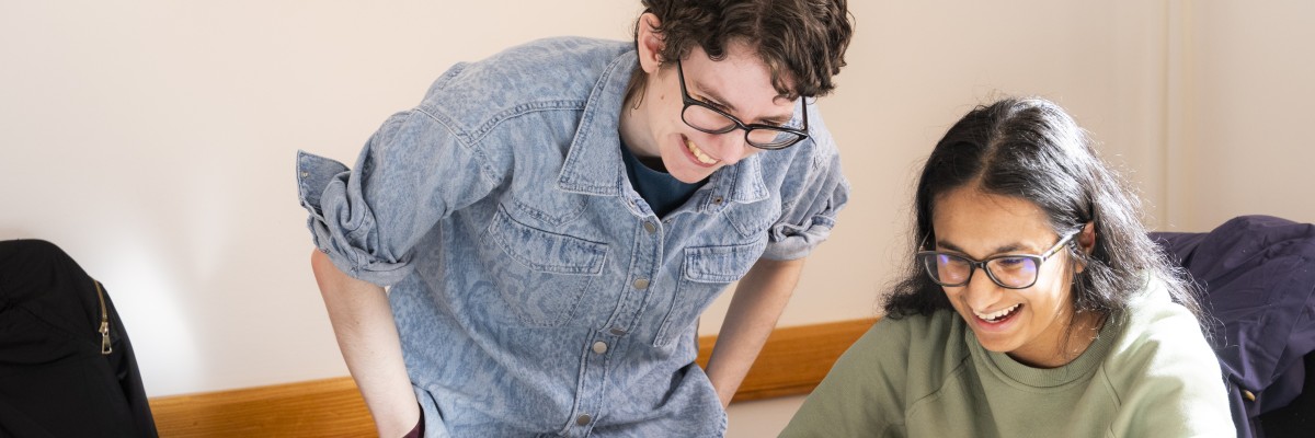 Students smiling at a laptop