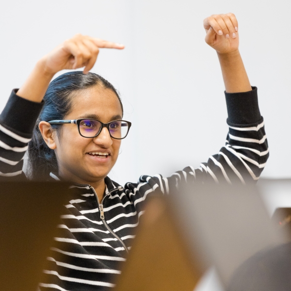 Image of a STOR-i student smiling, with her hands pointing off camera