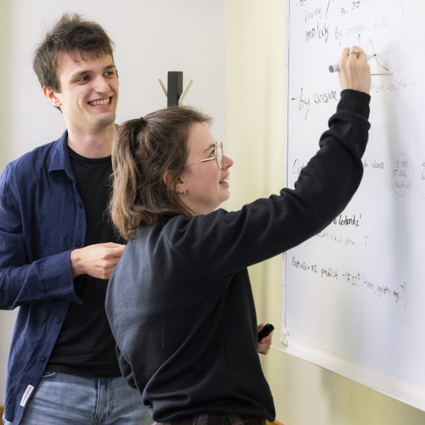 A student writing on a whiteboard at a Spring School event