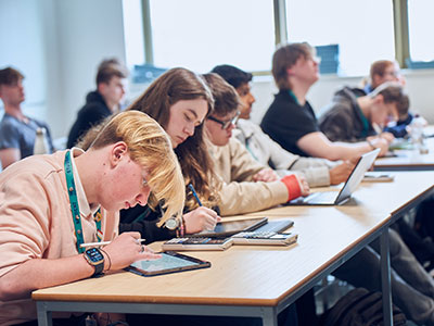 Students siting and working in a classroom.