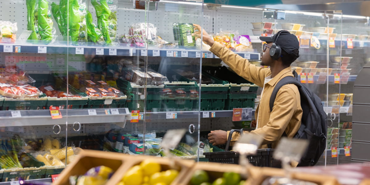 A student reaches into a chiller cabinet in the Spar to buy groceries.