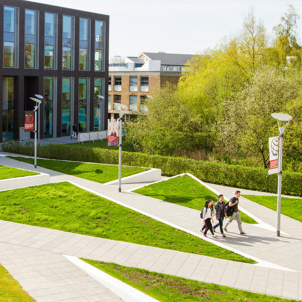 Students walk across the plaza in front of the George Fox building.