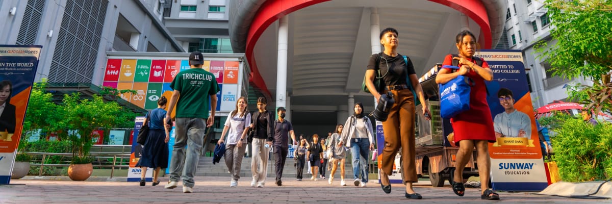 Students walk in and out of an imposing building at Sunway University.